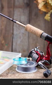 background with fishing tackles on old wooden board with leaf