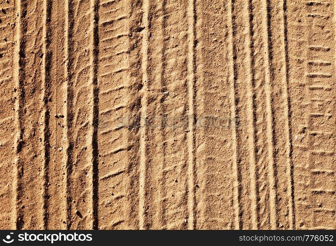 Background with tire tracks on a sandy road in sunny day