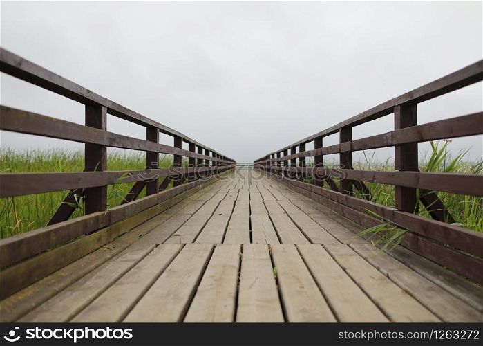 background with wooden bridge with fence and cloudy sky.. background with wooden bridge with fence and cloudy sky