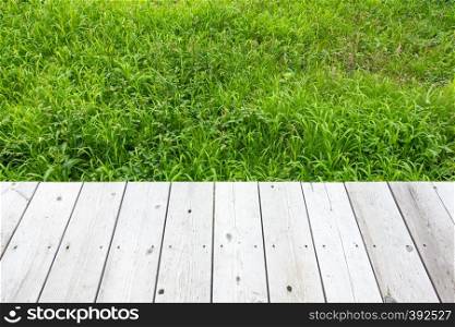 Background wooden and background grass. Wooden floor on grass in garden.