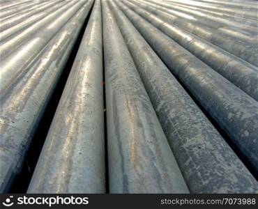 Backgrounds and textures: big group of zinc-coated steel pipes, diminishing perspective. Zinc-coated steel pipes