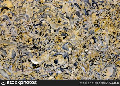 Backgrounds and textures: limestone, surface of beautiful yellow-grey decorative stone, abstract pattern of cracks, spots and stains, natural background. Abstract mineral texture