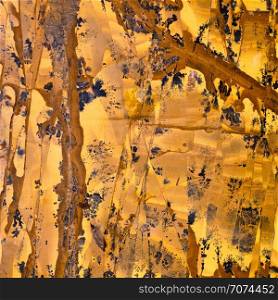 Backgrounds and textures: marble, surface of beautiful orange-yellow decorative stone, abstract pattern of cracks, spots and stains, natural background. Abstract mineral texture