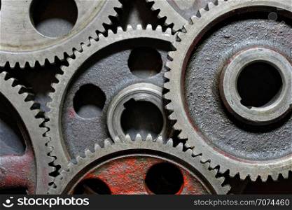 Backgrounds and textures: set of connected steel cogwheels, big, heavy and old, industrial abstract. Group of old steel cogwheels