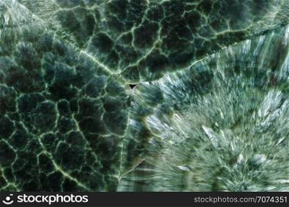 Backgrounds and textures: surface of beautiful green-white decorative stone, abstract pattern of swirls, twirls, lines, cracks, spots and stains, natural background. Abstract mineral texture