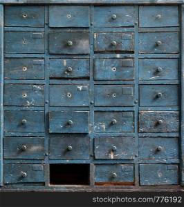 Backgrounds and textures: very old dark blue wooden cabinet with drawers. Old blue wooden cabinet with drawers