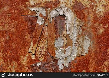 Backgrounds and textures: very old rusty metal wall surface, with number 70, industrial abstract. Very old rusty metal wall surface