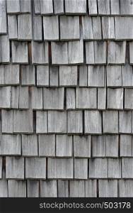 Backgrounds and textures: weathered wooden shingles, exterior wall or roof of rustic building. Old weathered wooden shingles