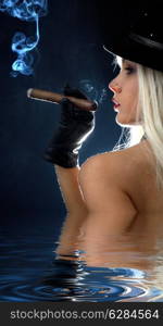 backlight image of topless girl smoking cigar in water&#xA;