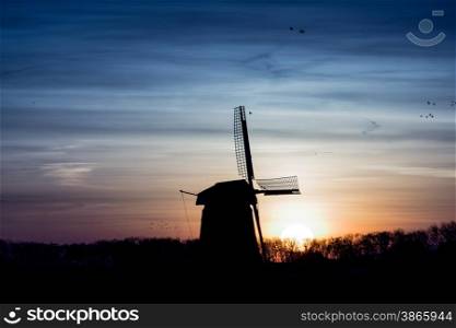 backlit Dutch windmill during sunrise