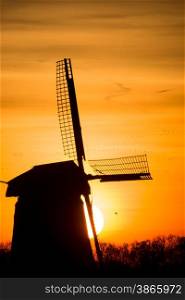 backlit Dutch windmill during sunrise
