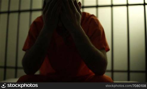 Backlit scene of a depressed inmate in prison