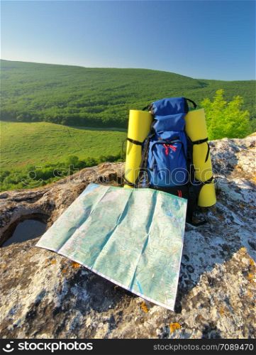 Backpack and map in mountain. Element of design.