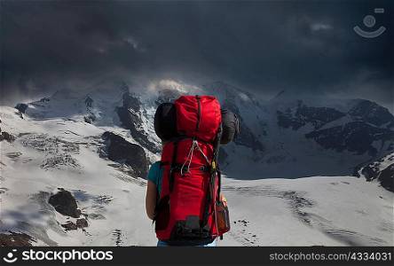Backpacker admiring stormy mountains