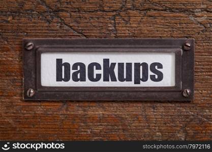backups - a label on a grunge wooden file cabinet