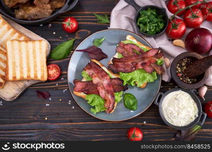 bacon and cream cheese sandwiches on a plate on wooden table at domestic kitchen.. bacon and cream cheese sandwiches on a plate on wooden table at domestic kitchen