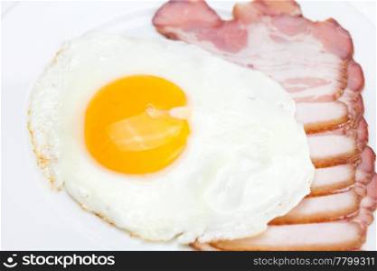 bacon and fried eggs on a plate isolated on white