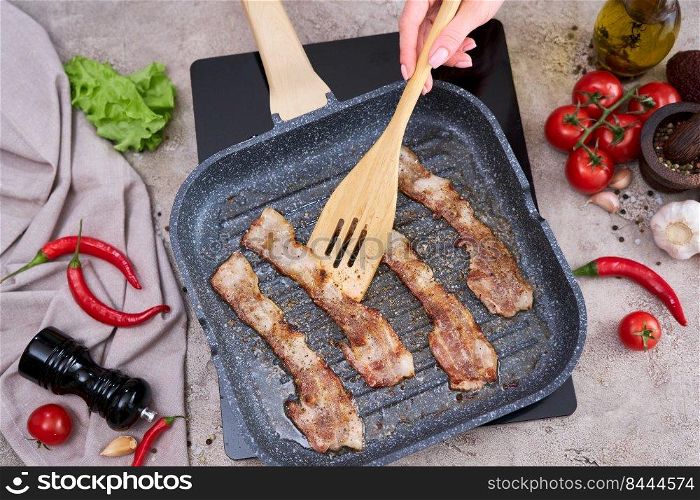 Bacon Being Cooked in grill frying pan Skillet at domestic kitchen.. Bacon Being Cooked in grill frying pan Skillet at domestic kitchen