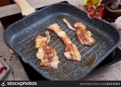 Bacon Being Cooked in grill frying pan Skillet at domestic kitchen.. Bacon Being Cooked in grill frying pan Skillet at domestic kitchen