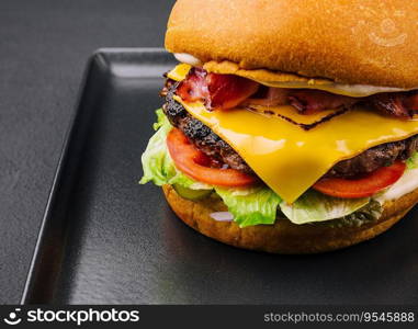 Bacon burger with beef patty on black tray