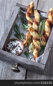 Bacon-wrapped breadsticks on the wooden tray