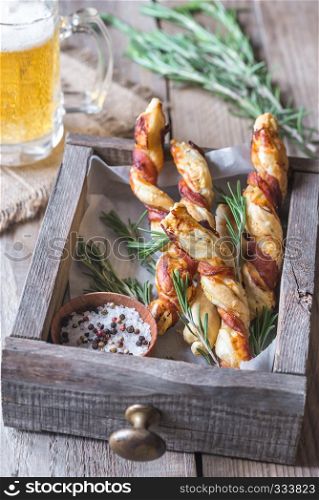 Bacon-wrapped breadsticks with mug of beer