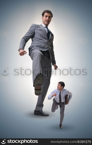 Bad angry boss kicking employee in business concept