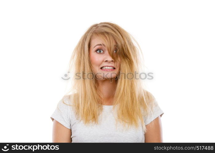 Bad hairstyle concept. Crazy, mad blonde woman with messy hair looking stressed out. Studio shot on white background.. Crazy, mad blonde woman with messy hair