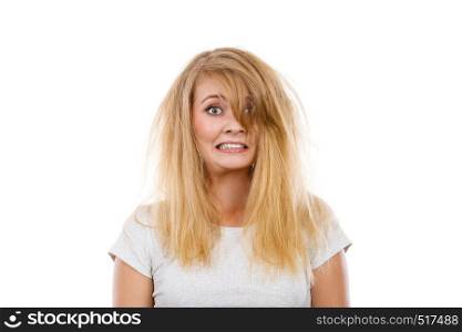 Bad hairstyle concept. Crazy, mad blonde woman with messy hair looking stressed out. Studio shot on white background.. Crazy, mad blonde woman with messy hair