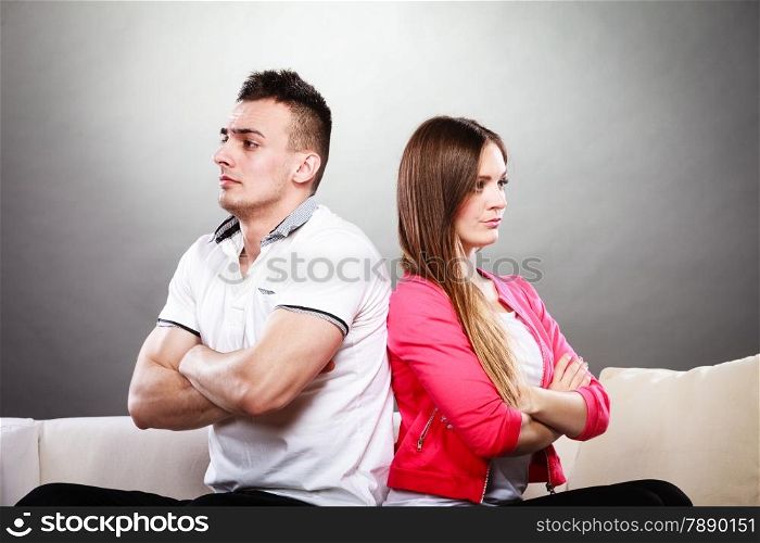 Bad relationship concept. Man and woman in disagreement. Young couple after quarrel sitting on sofa back to back