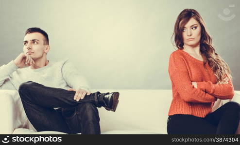 Bad relationship concept. Man and woman in disagreement. Young couple after quarrel sitting on sofa