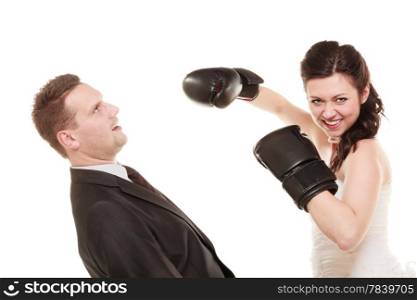 Bad relationship- conflict. Funny married couple fighting. Wife showing her husband who&#39;s boss. Angry woman bride in wedding dress boxing punching man groom isolated on white