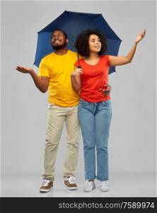 bad weather, overcast and protection concept - happy smiling african american couple in white t-shirts with umbrella over grey background. smiling african american couple with umbrella
