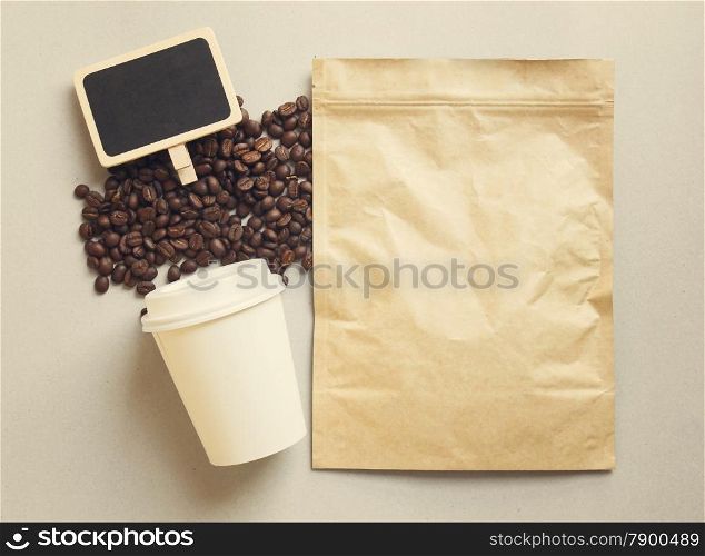 Bag of coffee and blank blackboard with paper cup, retro filter effect