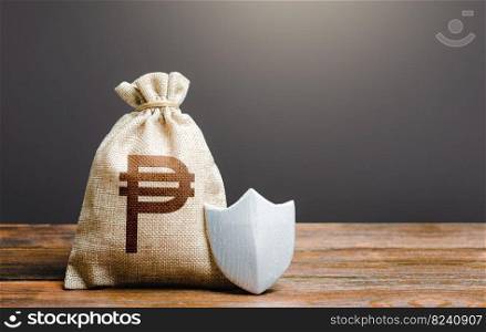 Bag with philippine peso symbol and protection shield. Ensuring the safety of investments in Philippines. Guaranteed protection of retirement savings. Reduction of corruption risks of doing business.