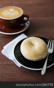 bagel with hot coffee on wood background