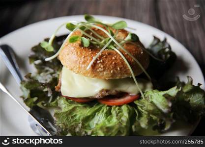 bagel with steak and cheese on wood background