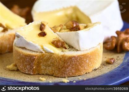 Baguette with camembert cheese and walnuts, photographed with natural light (Selective Focus, Focus on the first walnut piece on the bread)