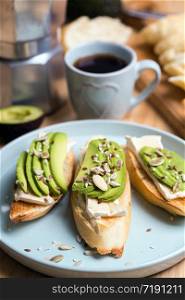 baguette with cheese brie and avocado with coffee and geyser