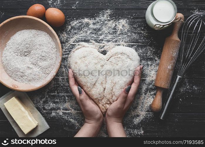 bake dough food ingredients on dark background.