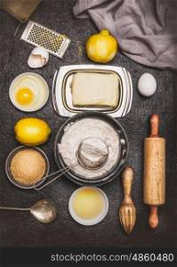 Bake ingredients and tools for lemon cookie or cake dough making on dark background, top view, flat lay