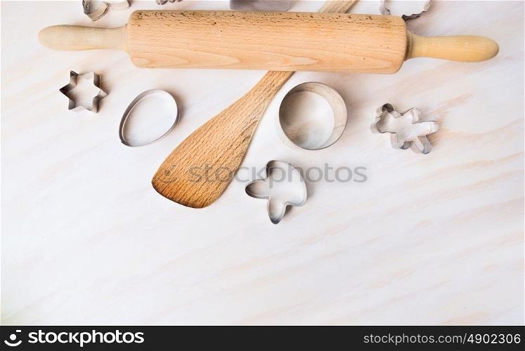 Bake tolls and easter cookie cutters on white wooden background, top view,place for text