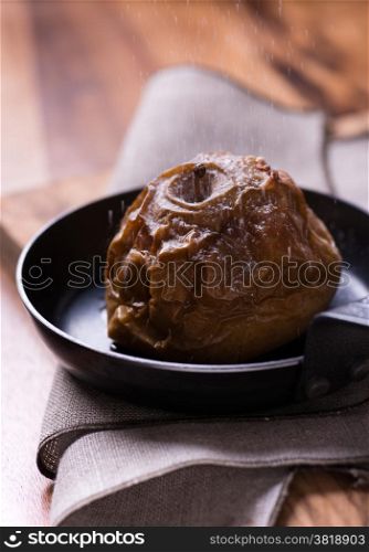 Baked apples on pan over wooden table, selective focus