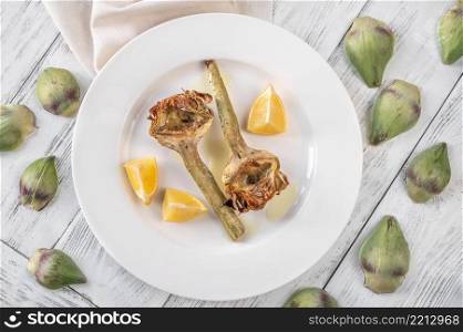 Baked artichoke with lemon on the plate