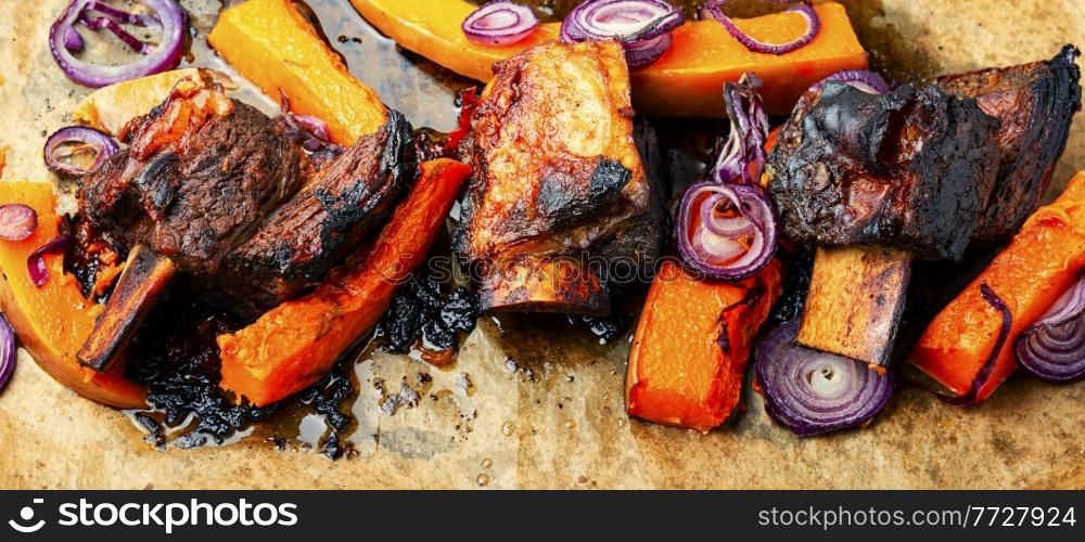 Baked beef ribs with pumpkin.Roasted veal meat with slices of pumpkin. Tasty beef ribs BBQ