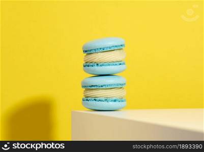 baked blue round macarons on a yellow background, delicious dessert