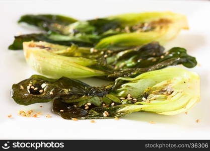 Baked bok choy or pak choi seasoned with soy sauce and roasted sesame seeds, photographed with natural light (Selective Focus, Focus in the middle of the first bok choy)