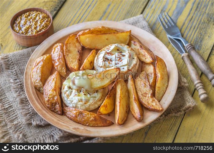 Baked Camembert cheese with roasted potatoes on the plate