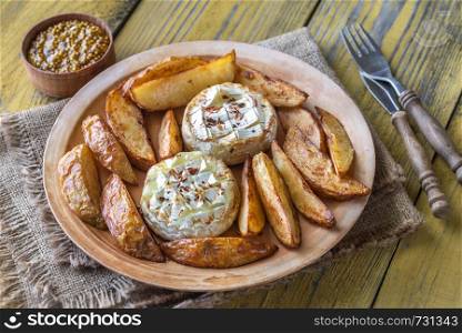 Baked Camembert cheese with roasted potatoes on the plate