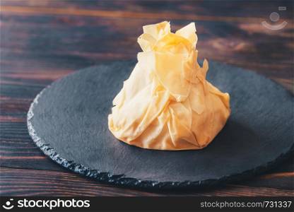 Baked Camembert in phyllo pastry on the black stone board